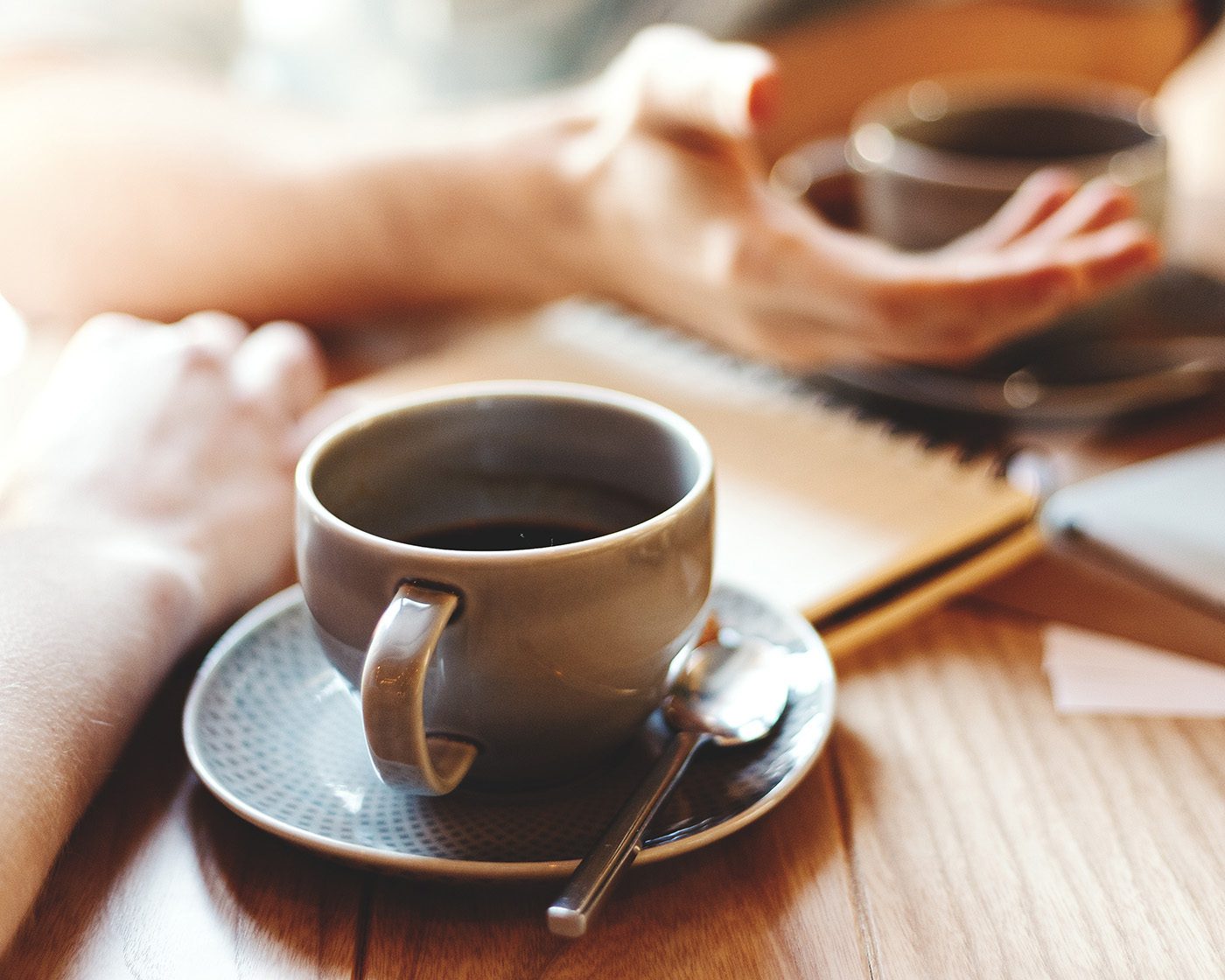 hands and coffee cups during conversation